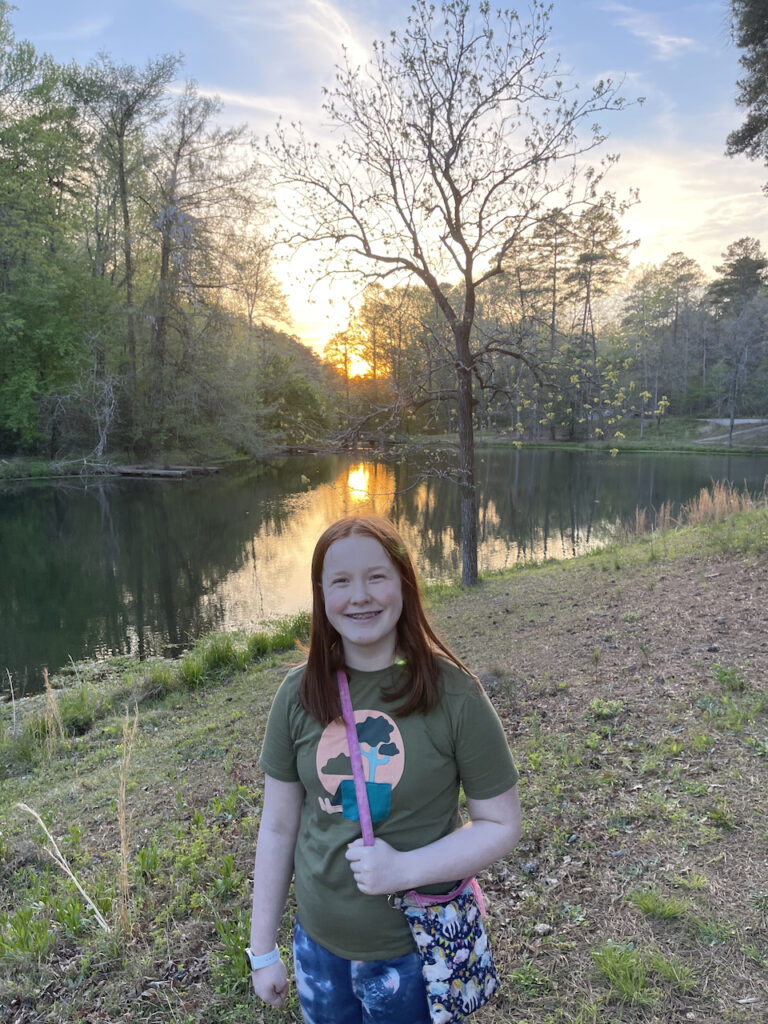 Cameron smiling on the shores of Desoto Lake near Hot Springs National Park. Taken at sunset with a strong yellow sky that is being reflected down into the water. 