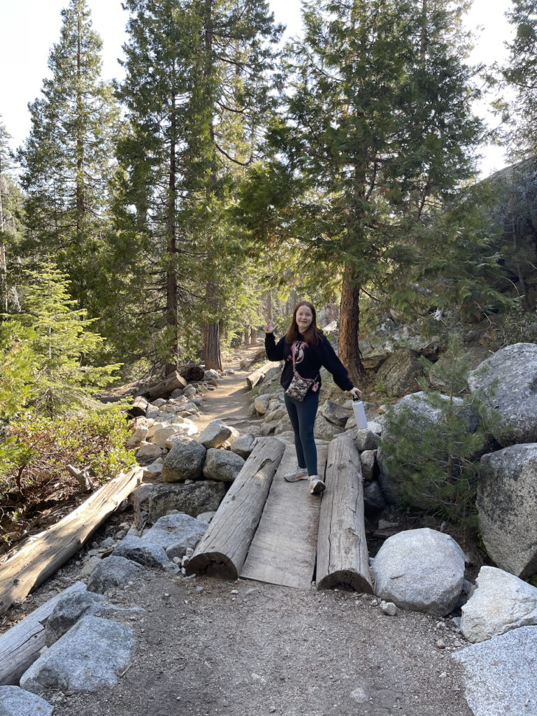 Cameron on a small wooden bridge over a creek in the woods on the Tokapah Falls Trail in Sequoia National Park.