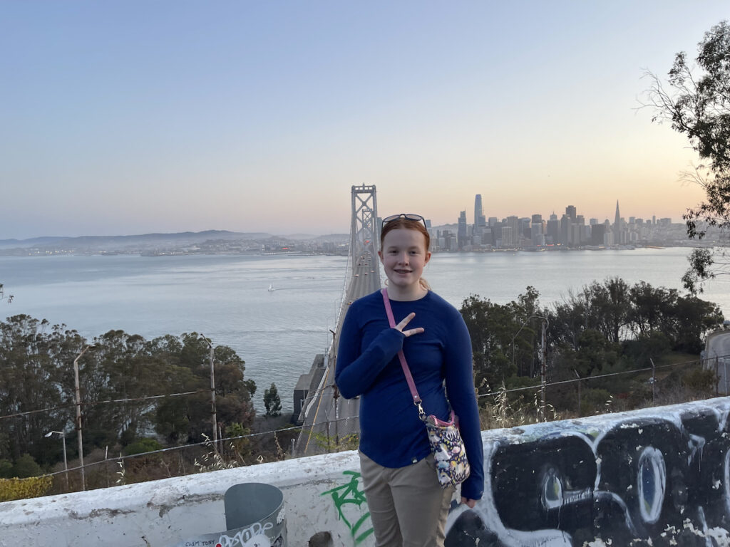 Cami making a peace sign at a well known location on Treasure Island as we wait for sunset. The Bay Bridge is right in front of us as well as the right of downtown.  