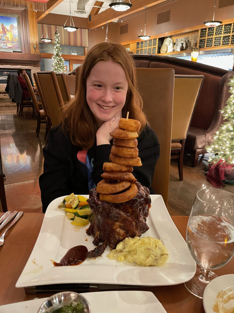 Cameron sitting inside a fancy restaurant (Switchback Grille) looking at a massive plate of ribs wondering how she is going to eat them all.