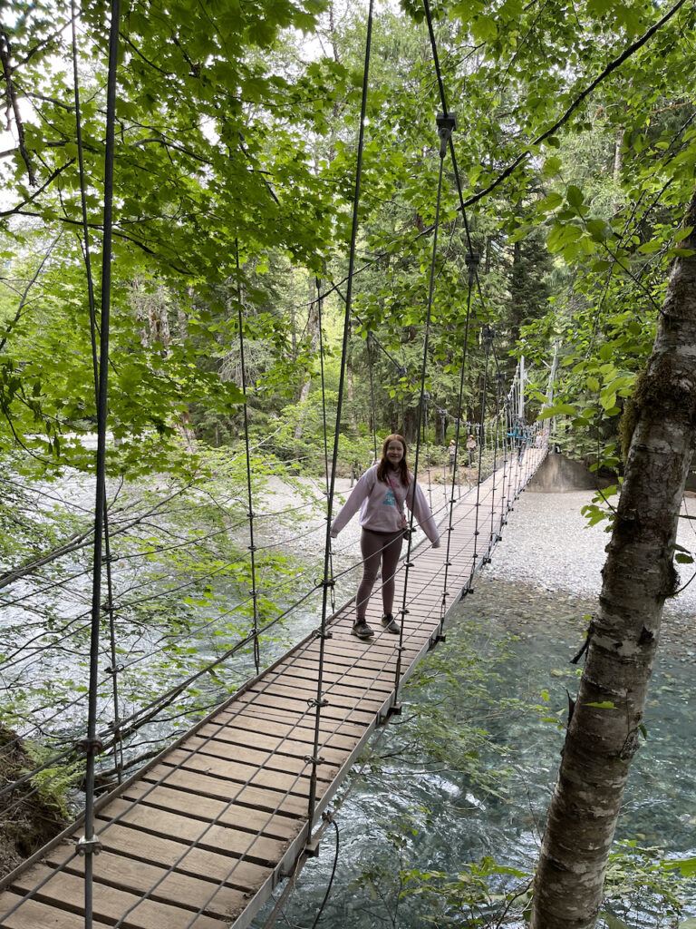 Cameron walking mid way on the suspension bridge on the trail that leads to the Grove of teh Patriarchs. 