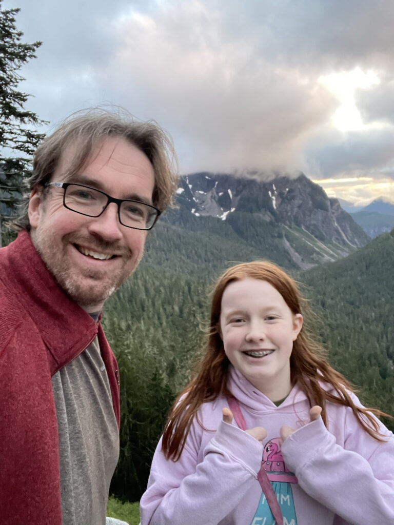 Cameron and myself on a high view point off Stevens Canyons Round in Mt Rainier as we watch sunset with massive storm clouds hugging the mountains behind us. Cami is giving two thumbs up for the incredible view. 