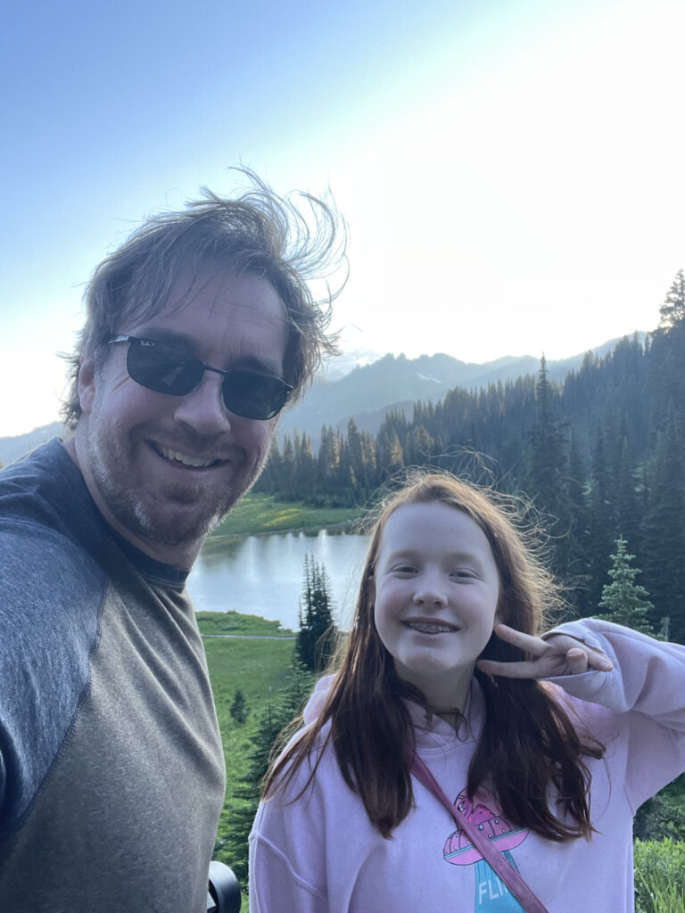 A photo of Cameron and myself near Tipsoo Lake in Mt Rainier. We are both smiling and Cameron is make a peace sign. 