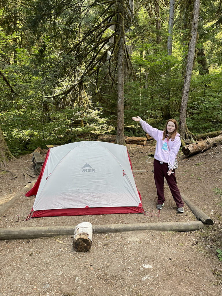 Cami excited that we had just setup our tent in the Colonial Creek Campgrounds, with forests all around us.