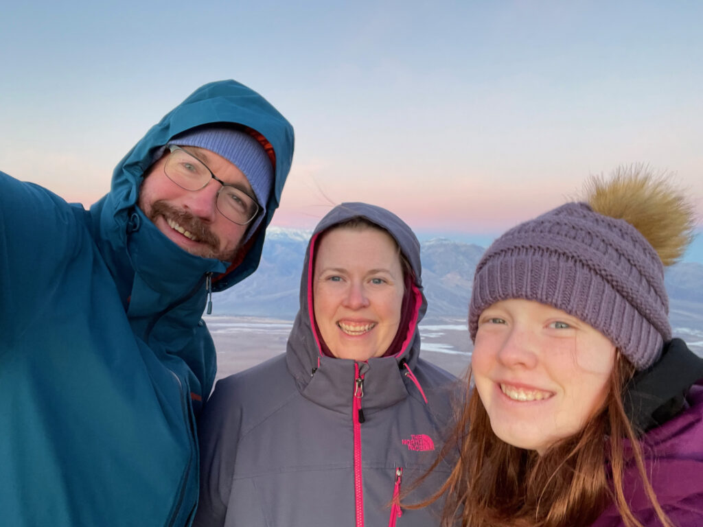 Cat, Cameron and myself all dressed for winter - standing at the peak of Dantes View - it was freezing cold and very windy. The sky is lit up across the valley at sunrise. 