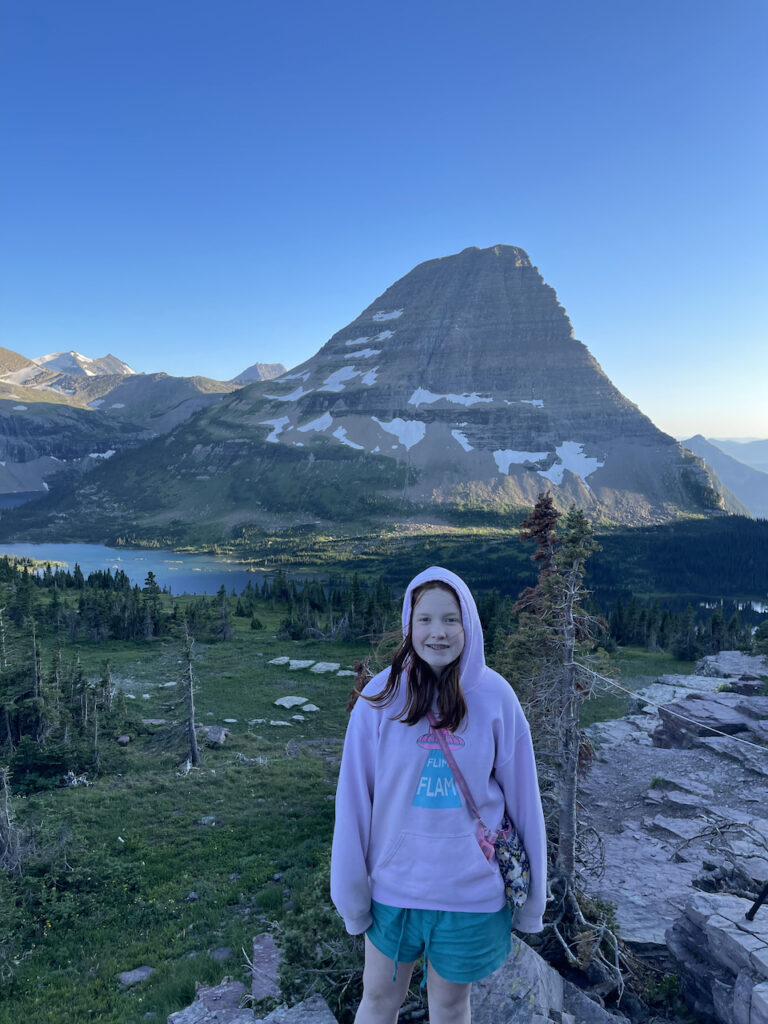 Cameron standing at the overlook at the end of the trail for Hidden Lake in Glacier National Park. The last light of day is just hitting the mountain in the background.