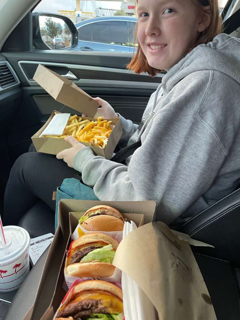 Cameron sitting in the passenger seat of the car, about to eat In-N-Out on our way to Page Arizona. 