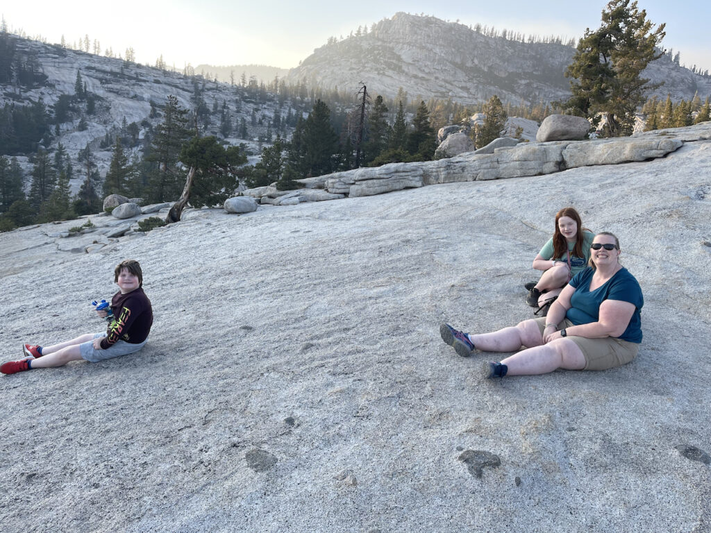 Cat, Cameron and Collin sitting on the rocky ledge at the end of the trail at Olmsted Point, waiting to watch the sunset in Yosemite.