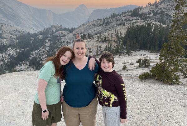 Cat, Cameron and Collin standing at the end of the trail to Olmsted Point, the amazing orange sunset happening in the background over Yosemite Valley and half dome.