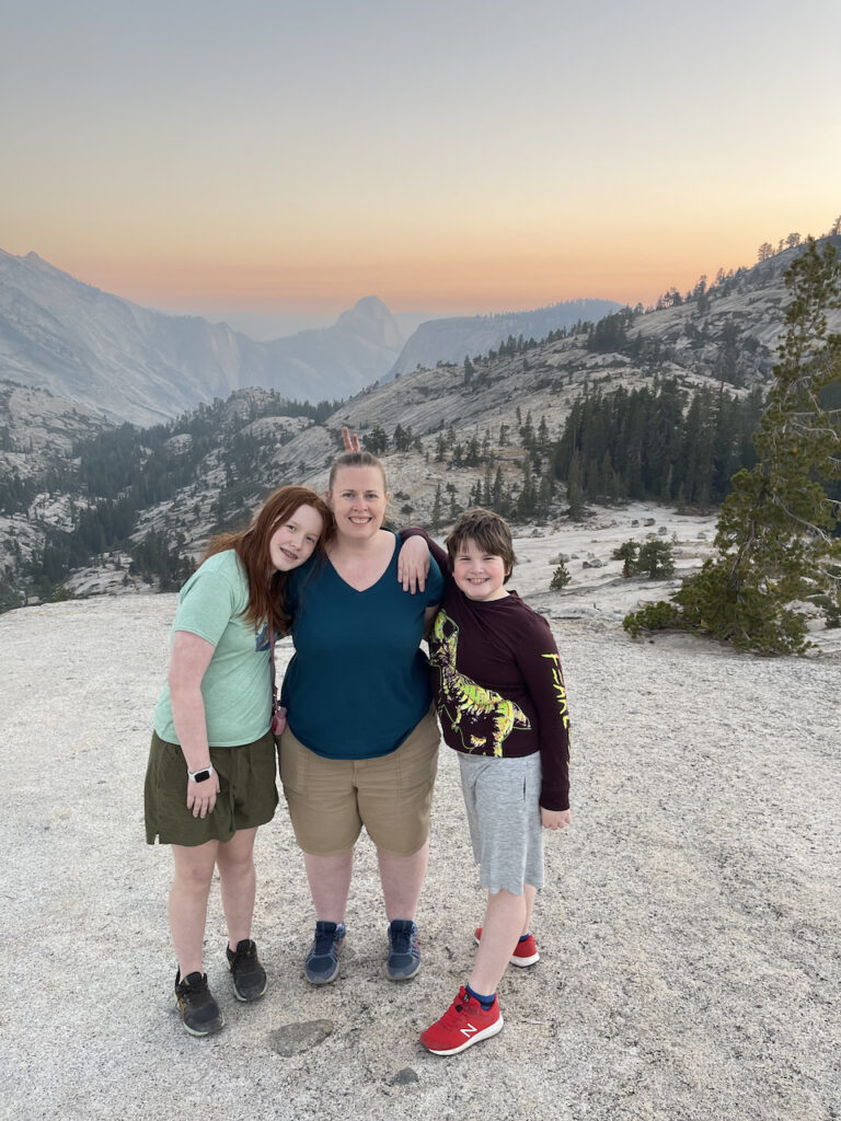 Cat, Cameron and Collin standing at the end of the trail to Olmsted Point, the amazing orange sunset happening in the background over Yosemite Valley and half dome. 