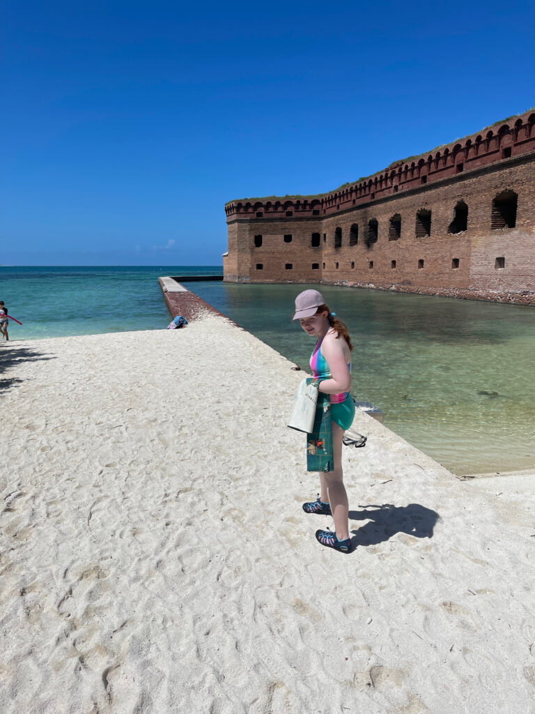 Cameron in her bathing suit and had walking on the sandy beach in Dry Tortugas right next to Fort Jefferson about to go swimming.