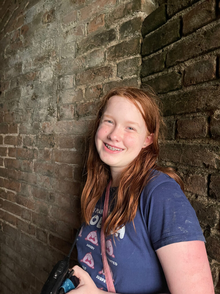 Cameron posing for a photo inside of Fort Jefferson. She is smiling while leaning on the brick wall.