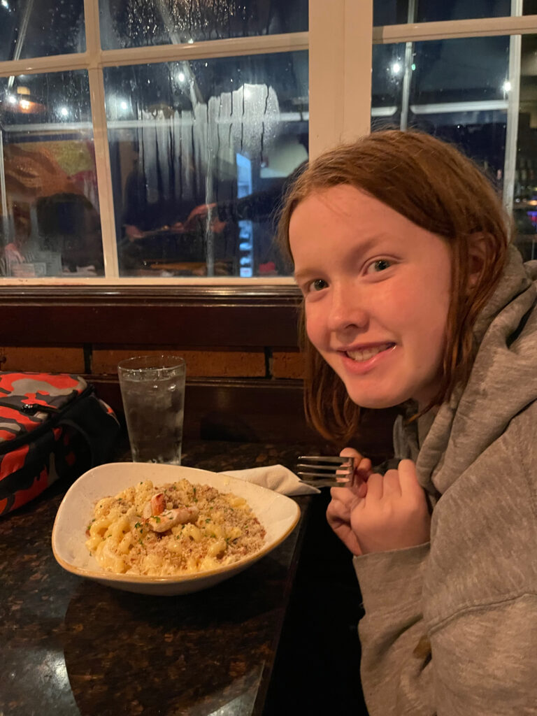 Cameron with her favorite meal on the table at the Pelican Brewing Company.