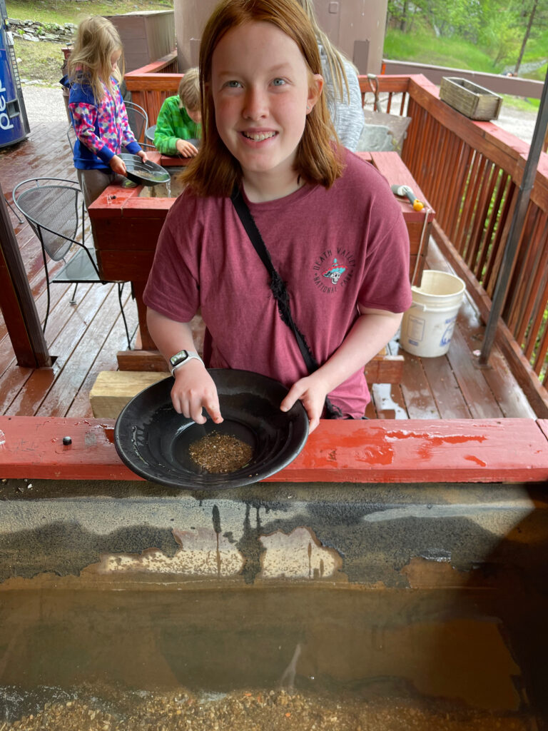 Cameron panning for gold at an old gold mine, outside near Mount Rushmore.