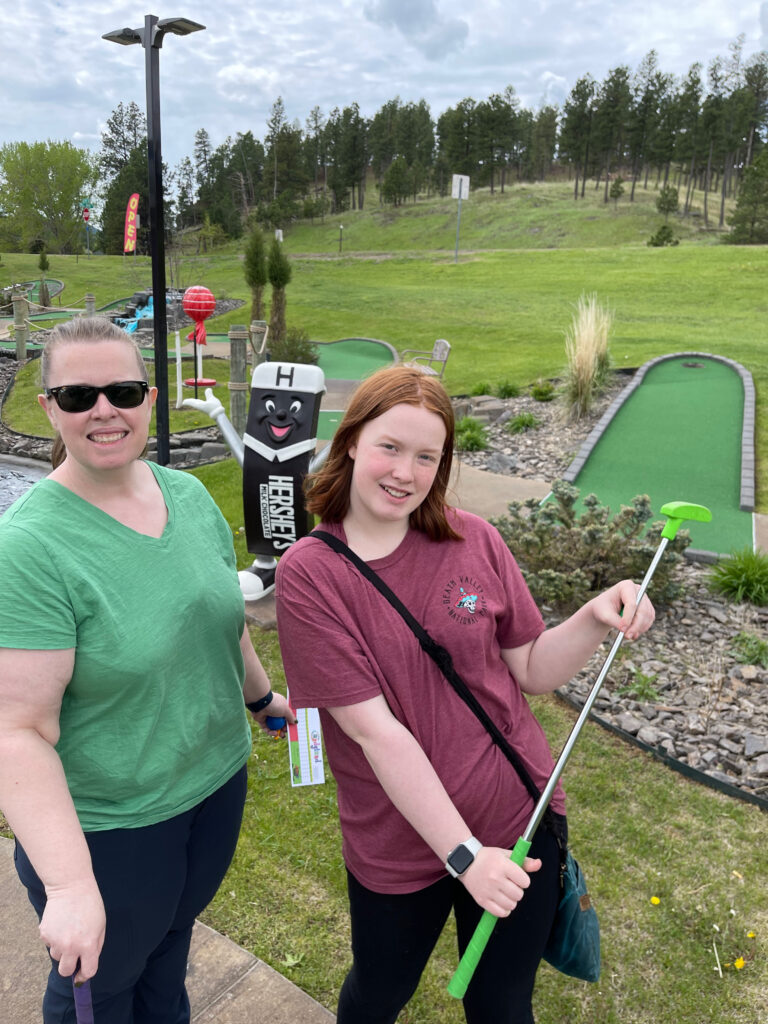 Cat and Cameron stop and pose for a photo while playing mini-golf in a small town in South Dakota.