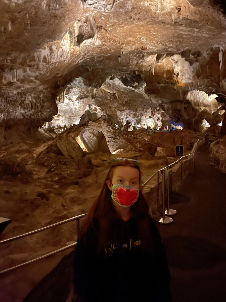 Cameron wearing a face mask and walking on the trail deep in Carlsbad Caverns.