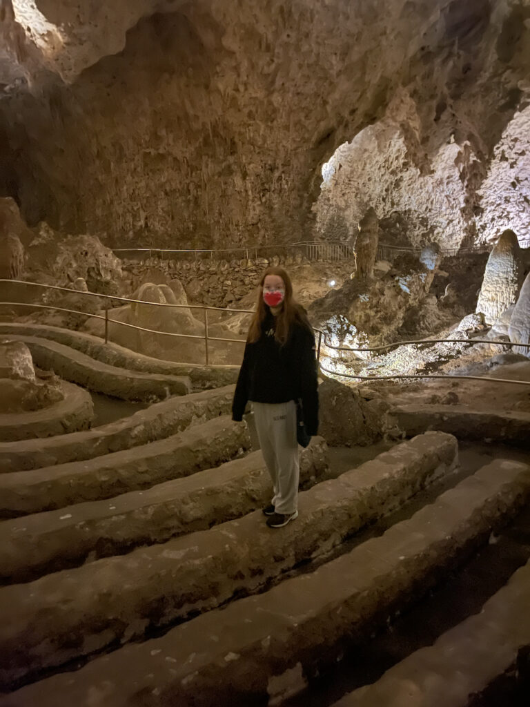 Cameron standing on one of the rock benches deep in Carlsbad Cavern.