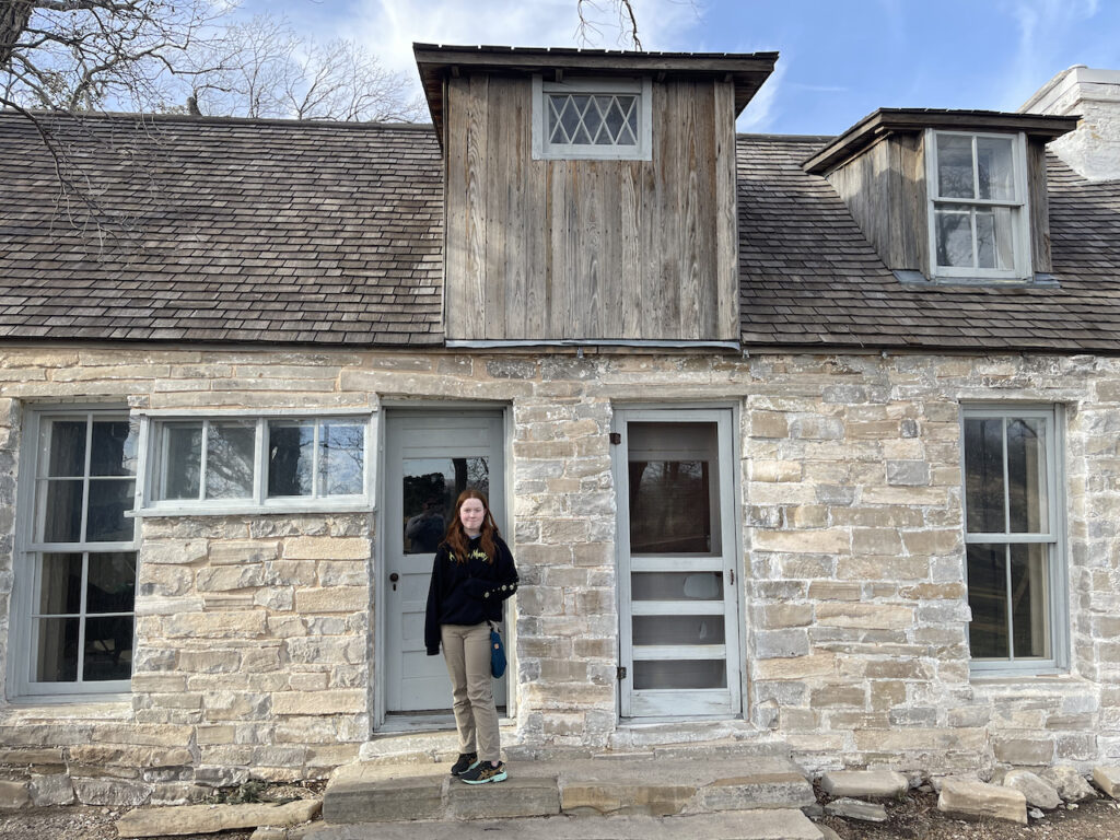 Cameron standing in front of the front door at Frijole Ranch.