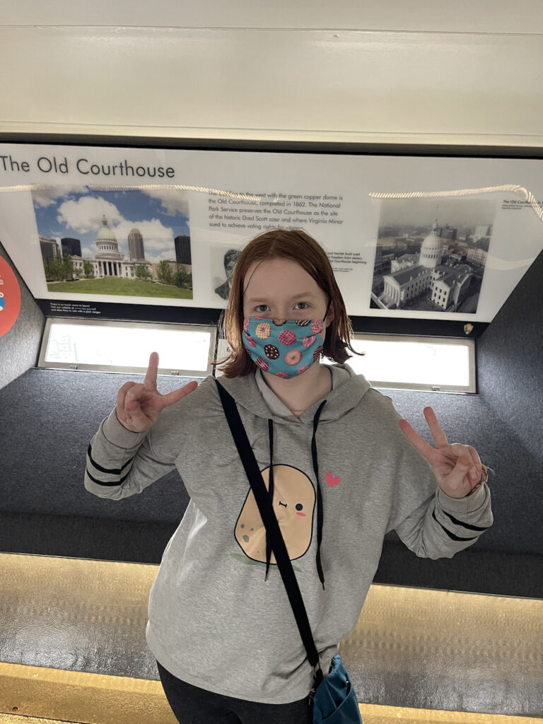 Cameron at the top of the Gateway Arch, making a double peace sign with her hands.