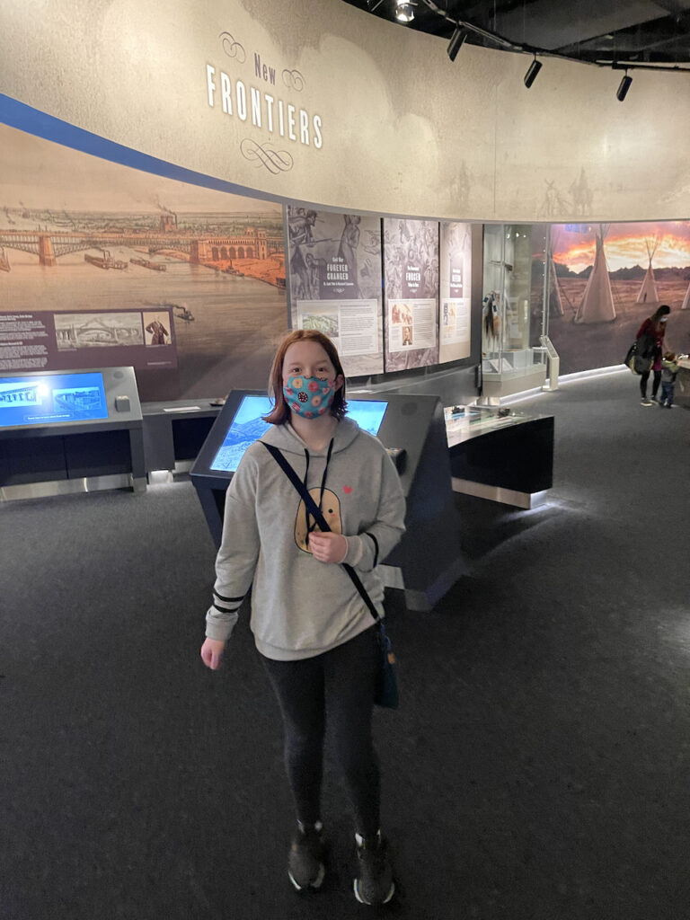 Cameron wearing a face mask for a photo inside the Museum under the Gateway Arch.