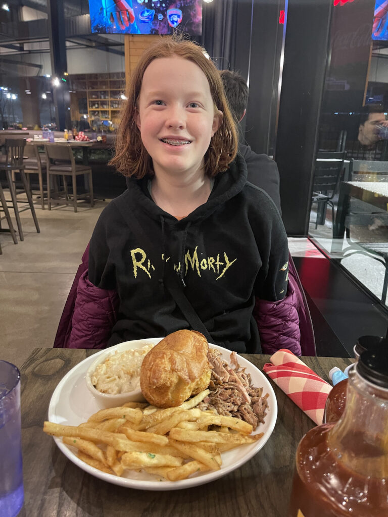 Cameron with her short red hair - eating a plate full of pulled port at Salk + Smoke in St Louis. 