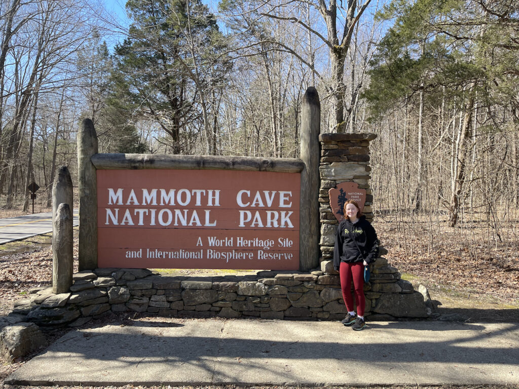 Cameron all smiles standing in front of the sign for Mammoth Caves National Park.