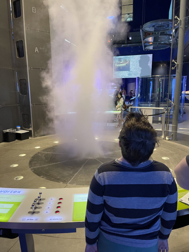 Collin looking up at a massive tornado exhibit in the Museum of Science and Industry. 