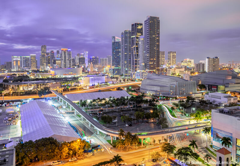 Miami skyline before dawn from high-rise on Biscayne Bay with Adrienne Arsht Center, Knight Concert Hall, FTX Arena, and car light trails.