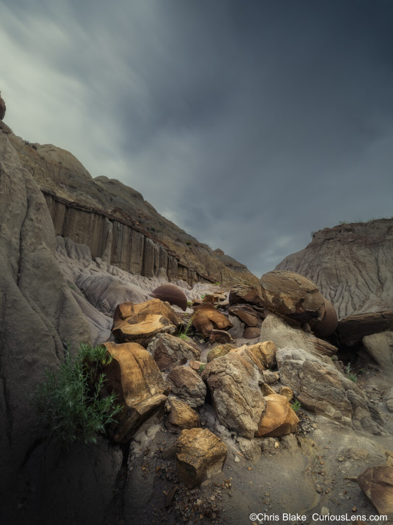 Cannonball Concretions in Theodore Roosevelt National Park's North Unit with moving clouds, porous sandstone, and spherical rock formations in the valley."