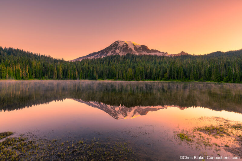 Reflection Lakes in Mount Rainier National Park with a clear view of Mount Rainier, perfect reflection, and early morning fog on the water.