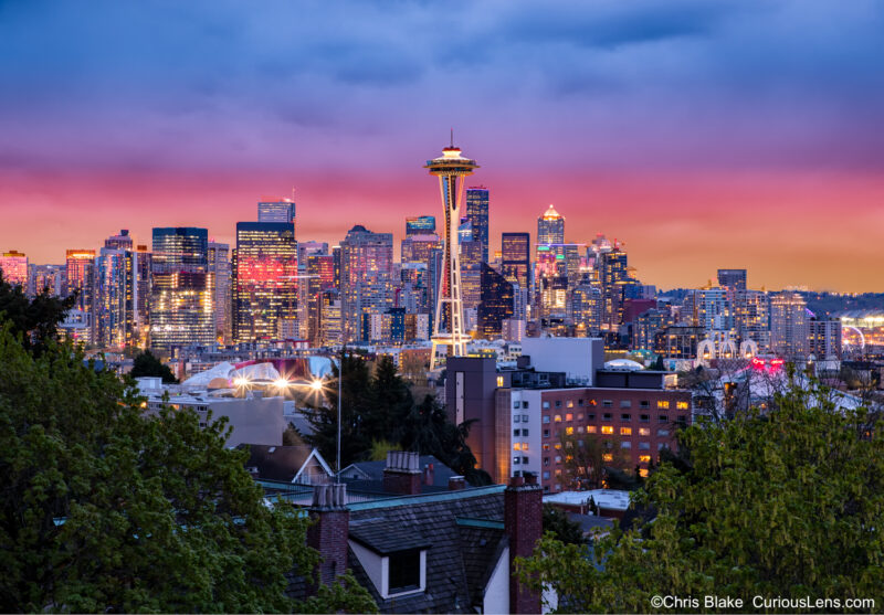 Space Needle at sunset from Kerry Park in Seattle with vibrant clouds, city skyline, and blue hour lights.