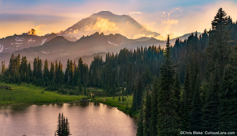 High alpine lake near Chinook Pass in Mount Rainier National Park at sunset with clouds, rays of light, and stunning mountain view.