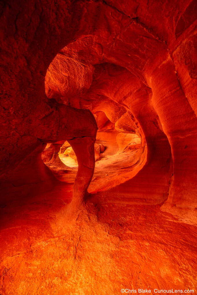 Windstone Arch in Valley of Fire State Park with red and orange glowing interior from reflected sunlight, sandstone cave erosion.