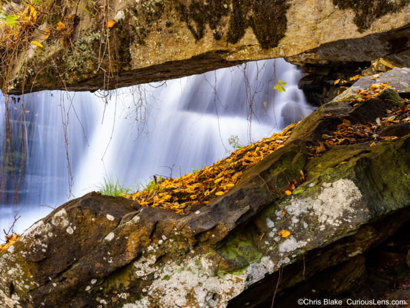 Unique rock formation in West Virginia with blurred water, vines, and leaves, captured with multiple filters and careful timing.