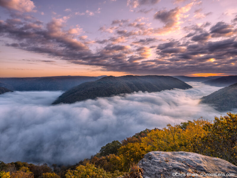 Grand View Overlook in New River Gorge National Park with cloud inversion, dramatic clouds, early fall colors, and view of the New River and Quinnimont.