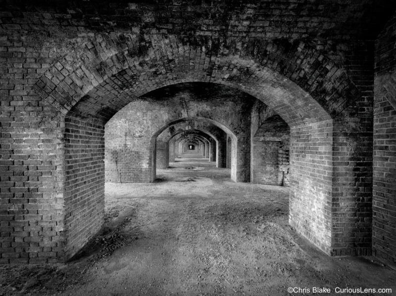 Historic Fort Jefferson in late afternoon with low sun creating dynamic lighting in long hallways.