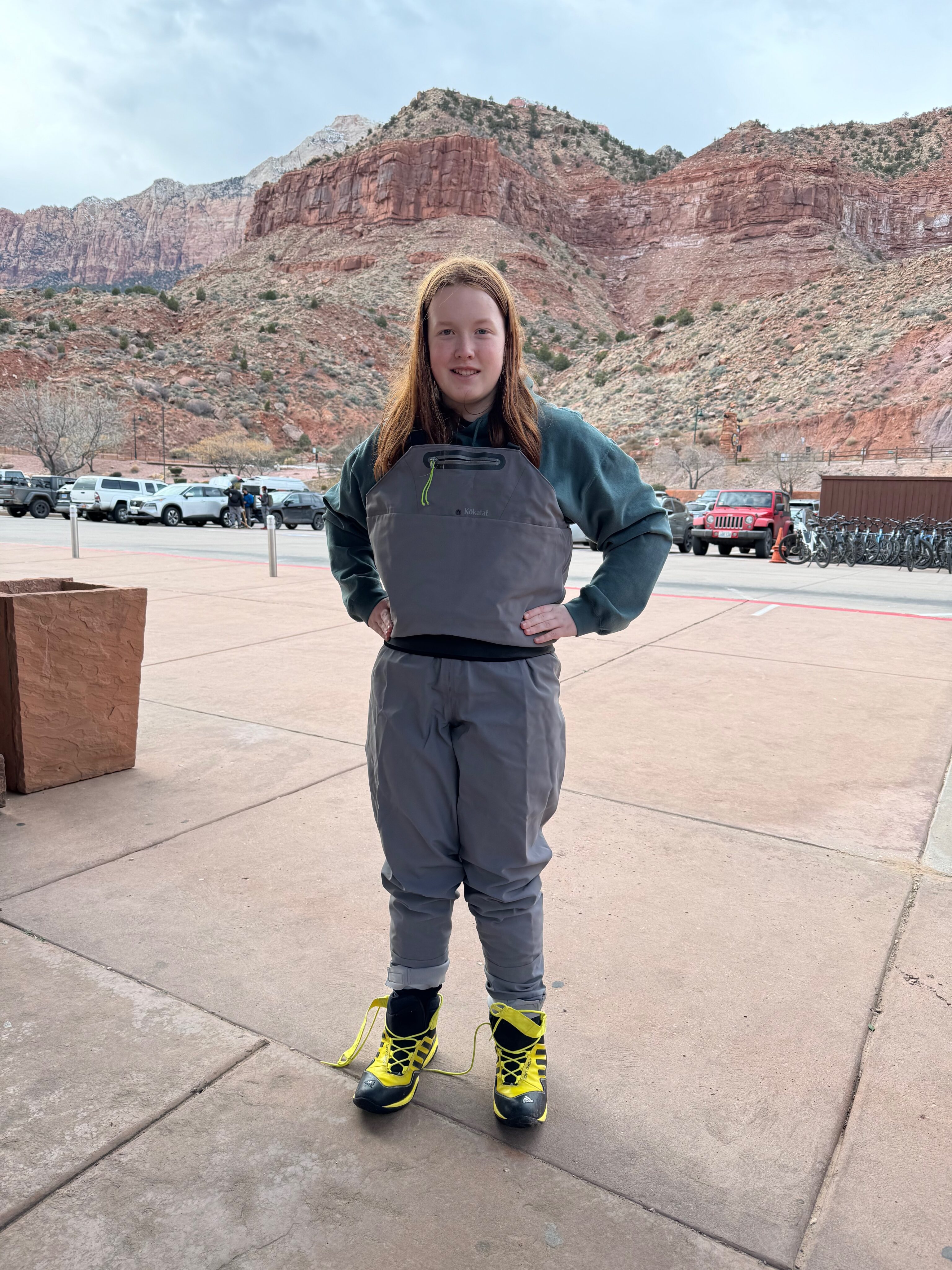 Cameron standing on the side walk outside the Zion Outfitters trying on the full wet suit for the Narrows Hike.