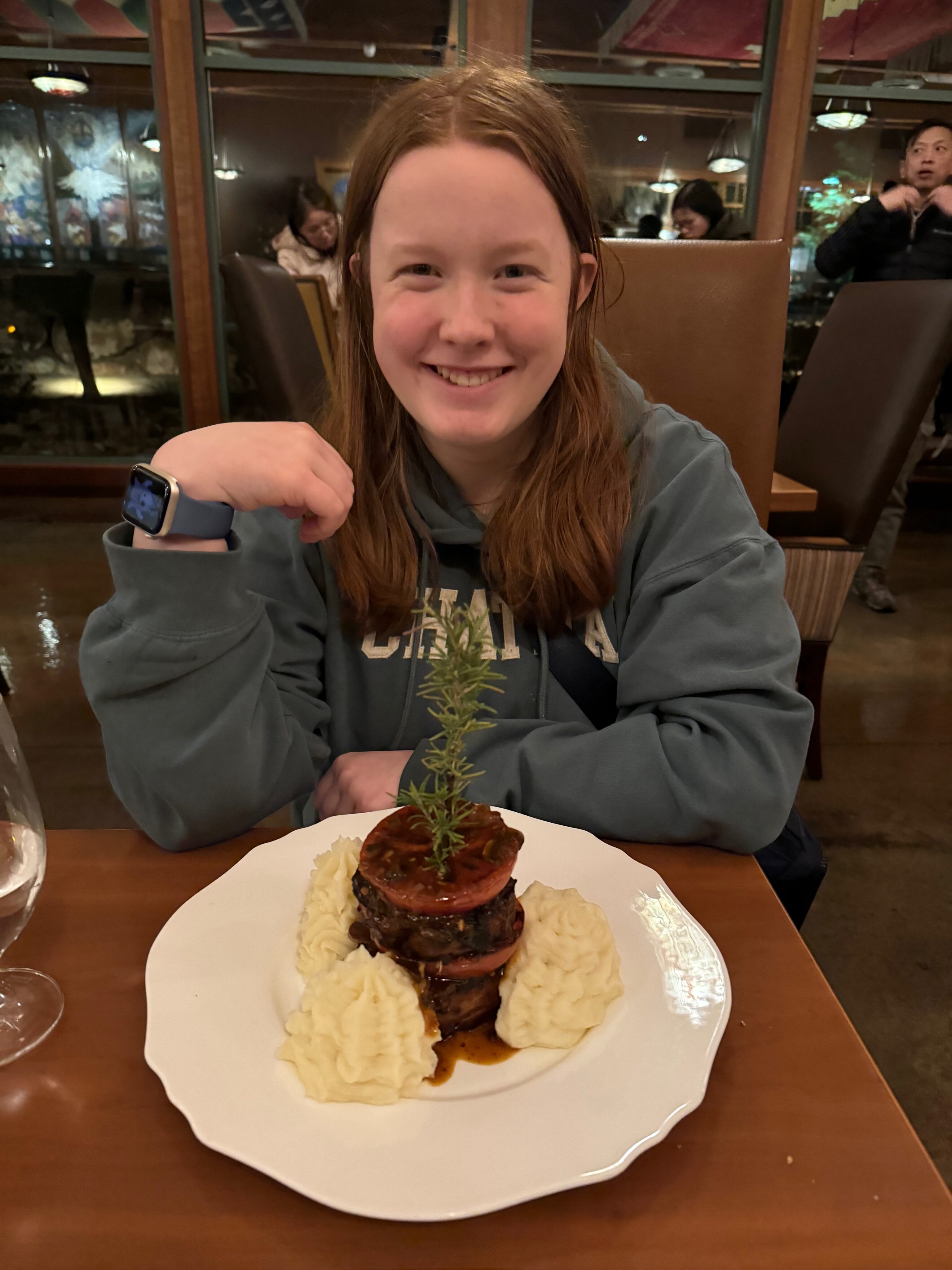 Cameron sitting at a fancy dining table in Springdale UT, with a massive plate of desert in front of her.