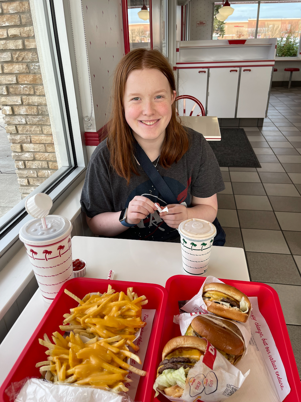 Cameron and myself sitting inside In-n-Out burger with a table full of food on our road trip in Oregon.