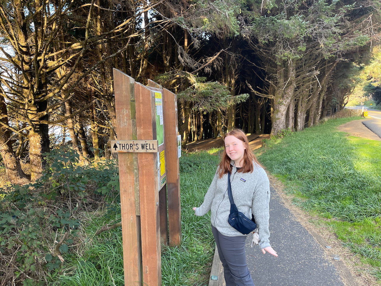 Cameron stops and poses on the trail next to the sign for Thors Well.