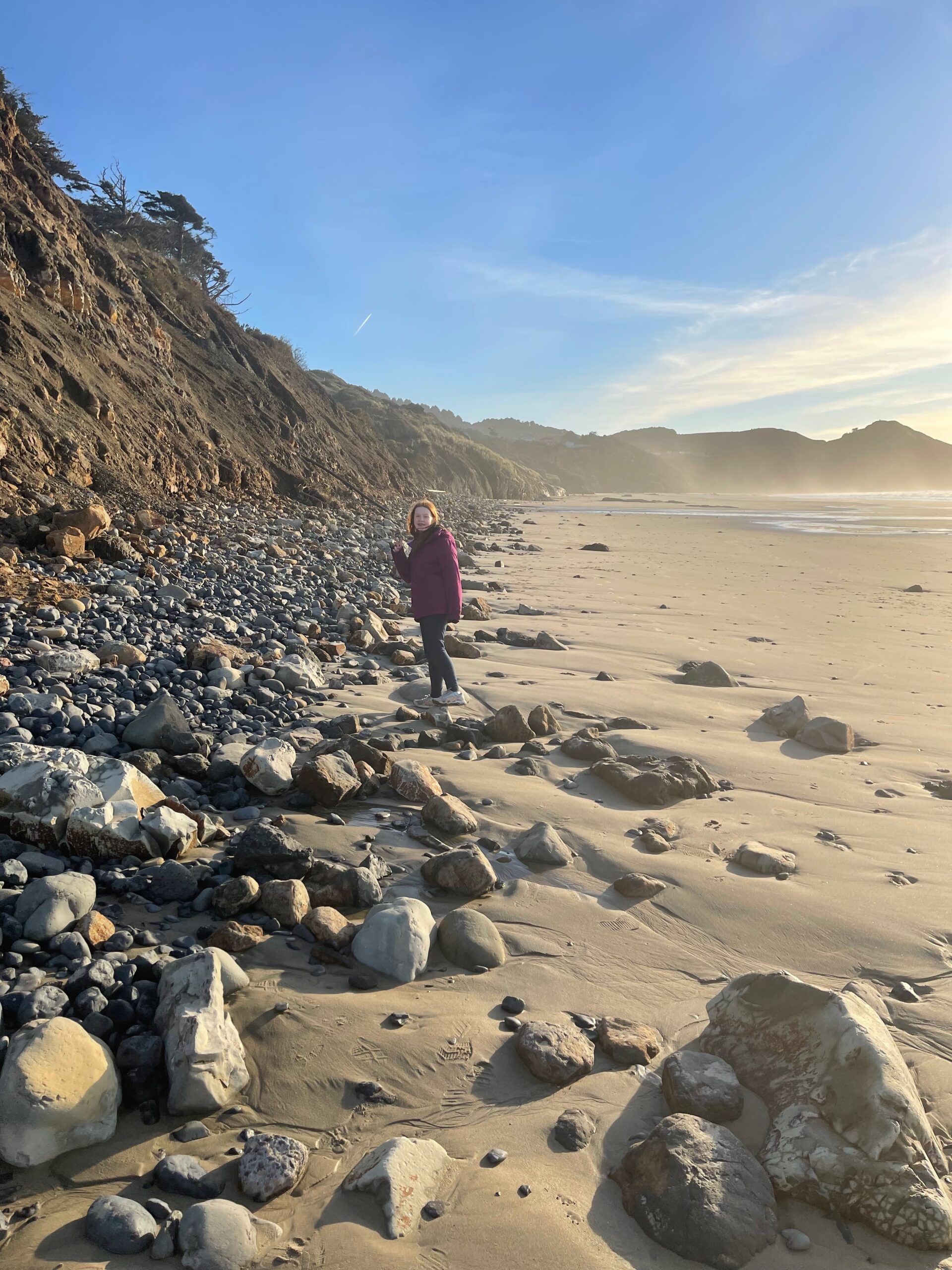 Cameron on the rocks where they meet the sand  near Starfish Cove on the Oregon coast. The mist from the crashing surf is making its way over to us.