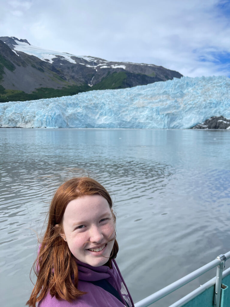 Cameron outside on the deck of the boat as we approach the Aialik Glacier in Kenai Fjords, the massive ice is meeting the ocean here and Cami looks back to smile. 