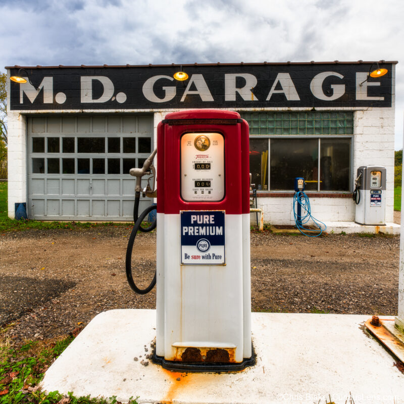 Restored vintage gas station in Boston, OH with illuminated lights, vintage pumps, and nostalgic charm.