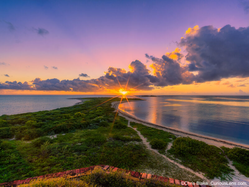 Sunrise at Fort Jefferson with views of Bush Key and Long Key, crystal blue waters, and breaking storm clouds.