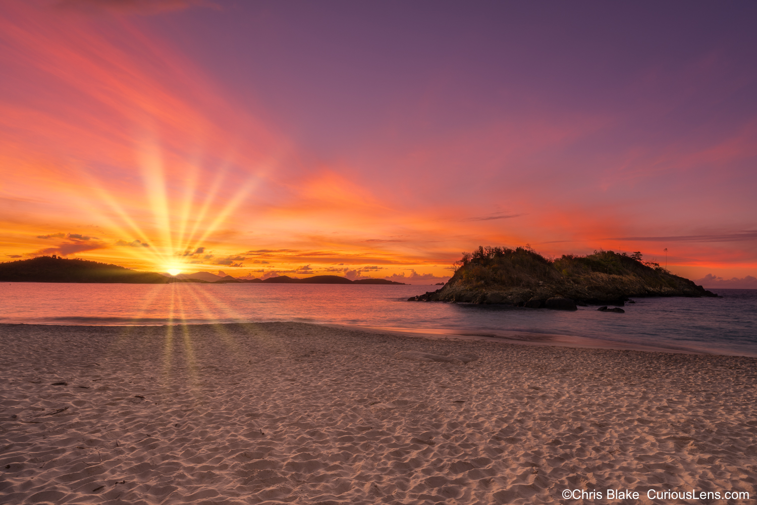 Stunning sunset at Trunk Beach in the Virgin Islands with red clouds, yellow sky, and reflections in the water.