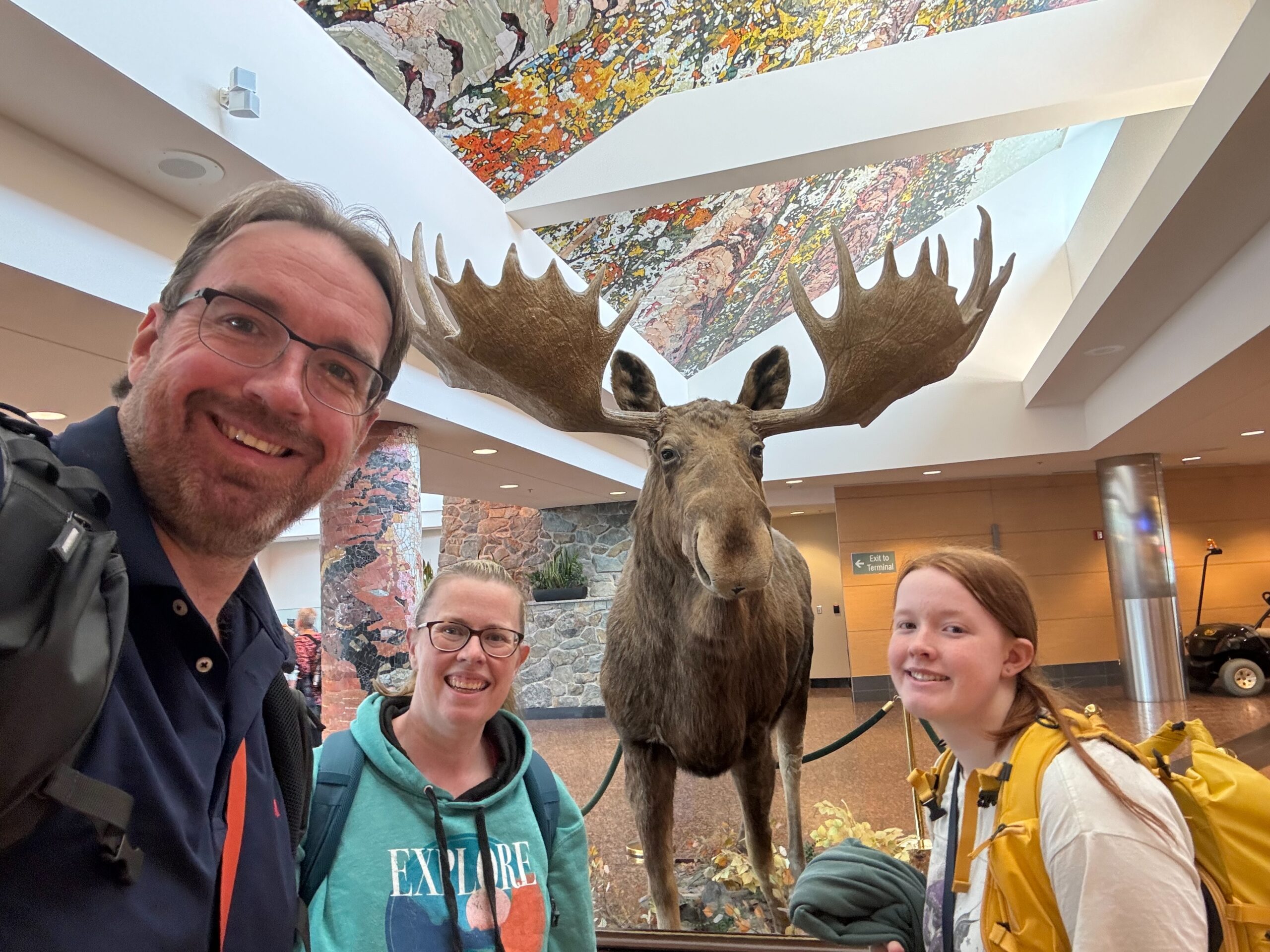 Cat, Cameron and myself standing in front of the giant moose in the airport in Alaska.