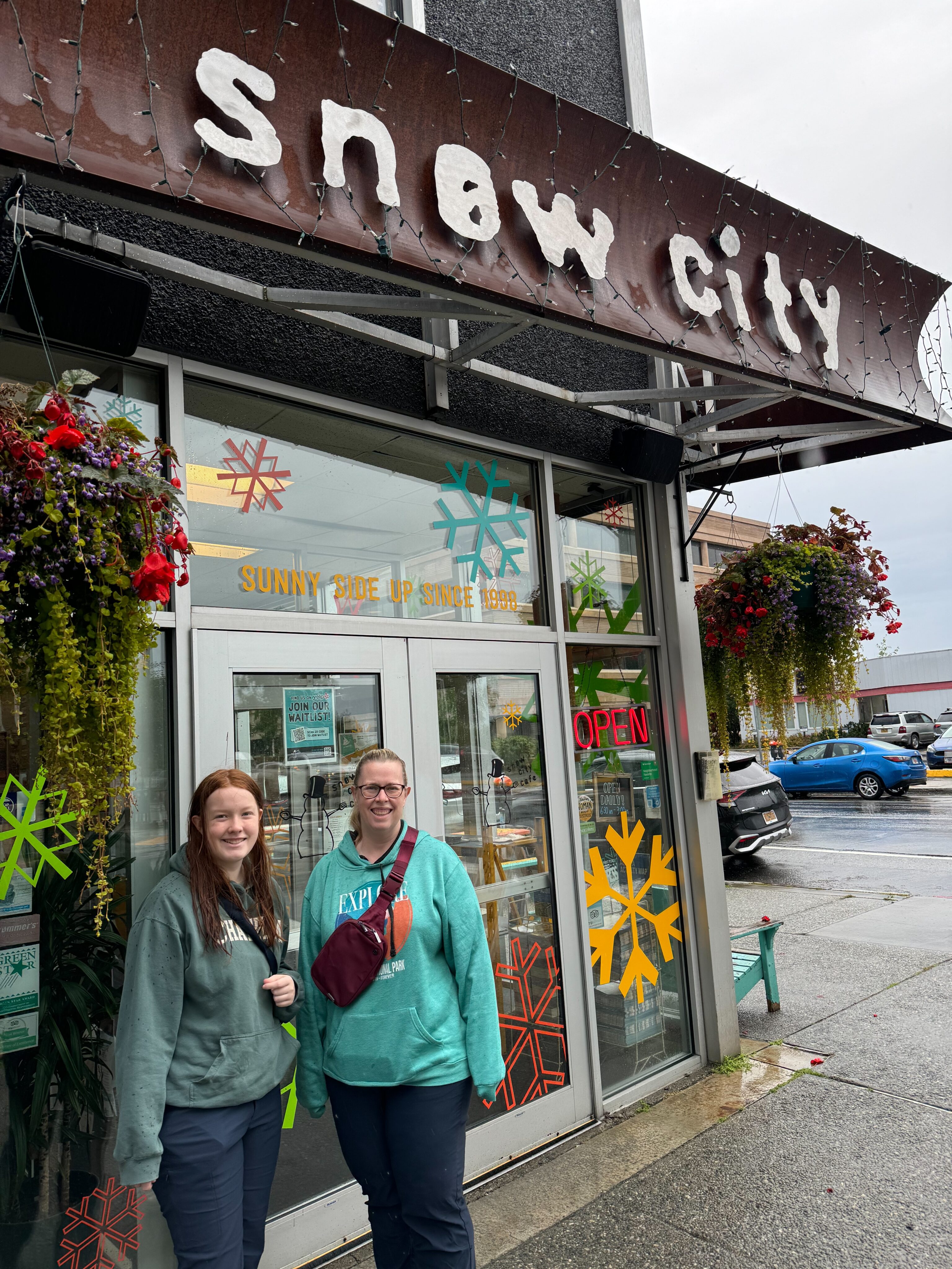 Cat and Cameron in the rain, standing outside the Snow City Cafe in Anchorage Alaska.