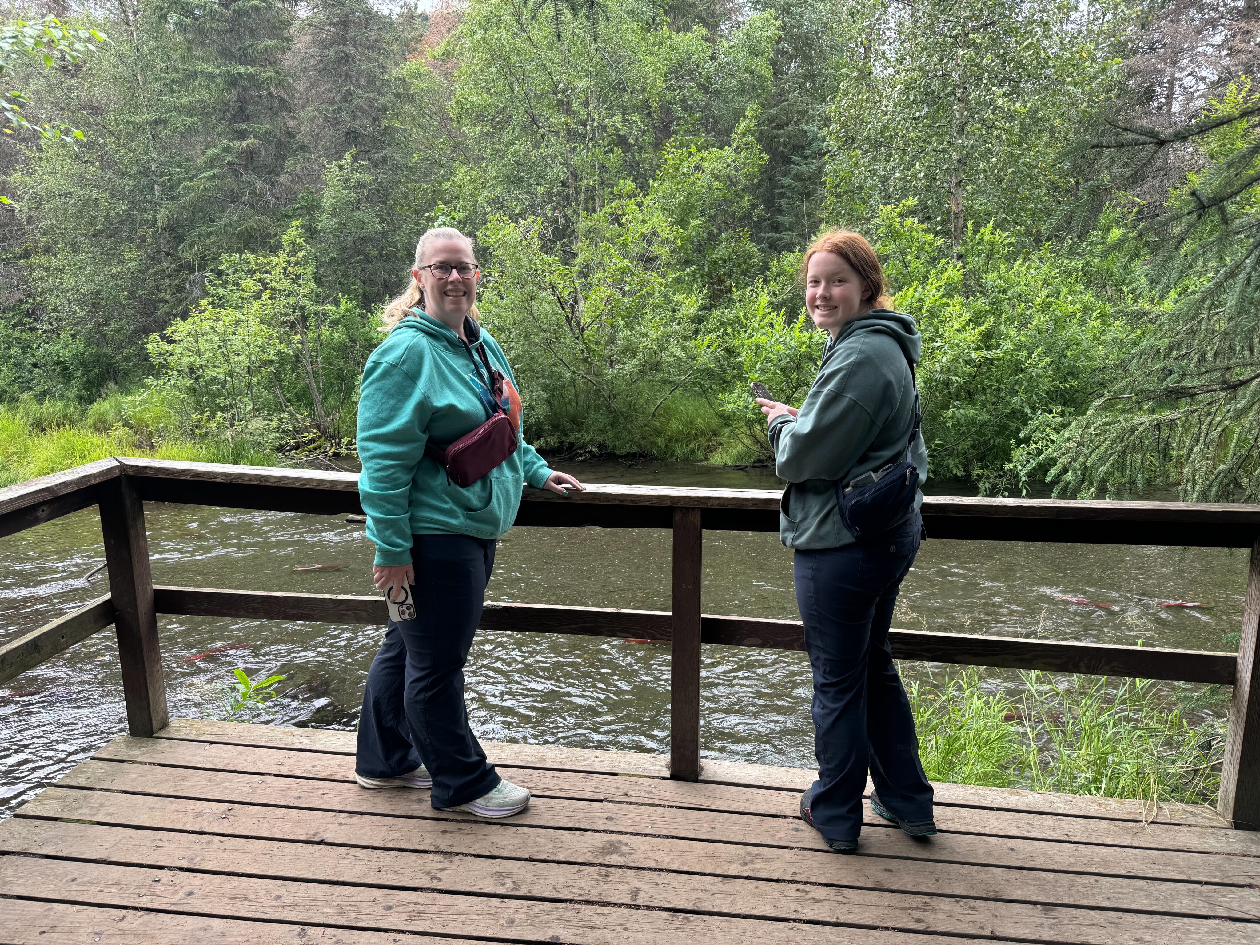 Cat and Cameron standing on the deck at the end of a hiking trail looking at the salmon from the hatchery