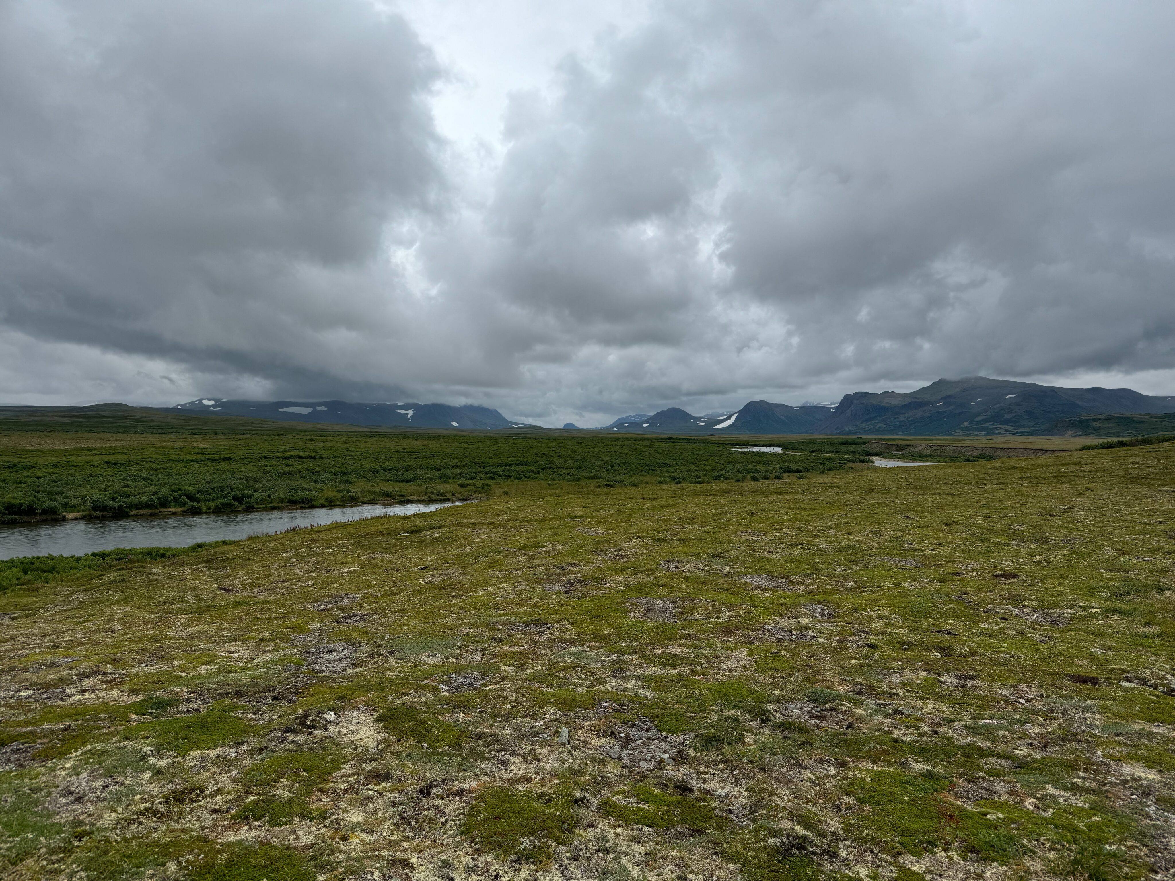 A stormy view of the tundra, river and the mountains in the distance in Katmai National Park.