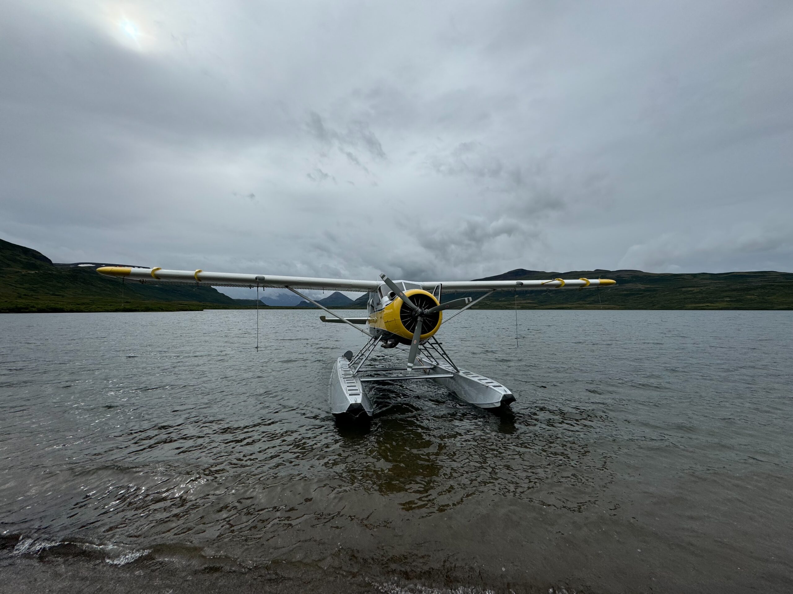 A 1954 de Havilland Beaver floatplane on the lake about to take us back to Lark Clark. Dark and cloudy skies are above us.